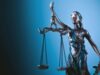 CFTC Sues Wisconsin in Escalating Fight Over Prediction Market Regulation A statue of Lady Justice holding scales in front of a blue background.