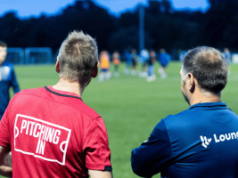 Entain presses football regulator over illegal gambling sponsorships at Premier League clubs Soccer coaches watching evening training session on grassroots soccer pitch during community football development program. Entain presses soccer regulator targeting illegal gambling sponsorships Premier League clubs