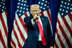 Trump declares prediction markets patriotic while state regulators wonder if Donald Trump points during campaign-style appearance surrounded by American flags amid debate over prediction markets and CFTC regulation.