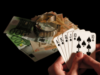 University researchers launch major independent UK gambling harms evidence center Person holding royal flush poker hand beside euro banknotes and luxury watch symbolizing gambling winnings, casino betting, and financial risk. University researchers launch major independent UK gambling harms evidence center