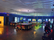Charlotte gambling raid nets arrests, cash, firearms, and over hundred machines Interior of 999 Arcade illegal gambling venue in Charlotte, North Carolina, showing rows of gaming machines, gambling stations, neon lighting, and seating areas during a CMPD investigation into alleged illegal gambling operations.