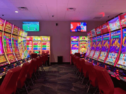 Tlingit and Haida opens Two Coppers Casino in Alaska amid ongoing tribal gaming debates Interior view of Two Coppers Casino in Juneau, Alaska, featuring rows of electronic gaming machines, red chairs, bright slot displays, and overhead television screens during the casino’s soft opening.